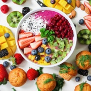 A bowl of food including berries, tropical fruits and other healthy ingredients.