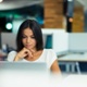 young office worker using a laptop and also sitting at a desk. 