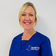 Sarah Hookes in royal blue MoNET scrubs against a white background.