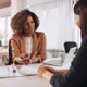 Two women having a meeting over a table. There are documents on the table in front of them.