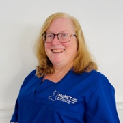 Belinda Cook in royal blue MoNET Scrubs against a white background.