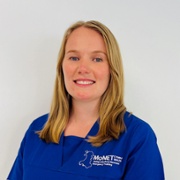 Catrin Jones wearing MoNET Royal blue scrubs in front of a white background. 