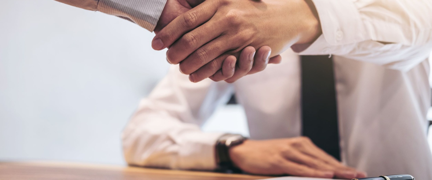 Two business people shaking hands over a business deal. 