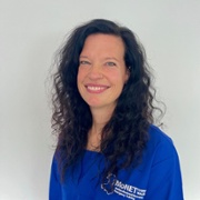 Jennifer Jones in royal blue MoNET scrubs against a white background.