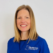 Dr Lisa Brown in royal blue MoNET scrubs against a white background.