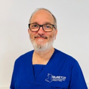 Dr Iyad Al-Muzaffar in royal blue MoNET scrubs against a white background.