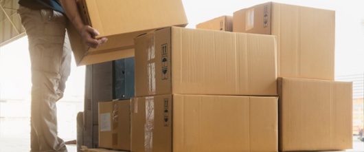 Worker courier lifting package boxes stacking on pallet