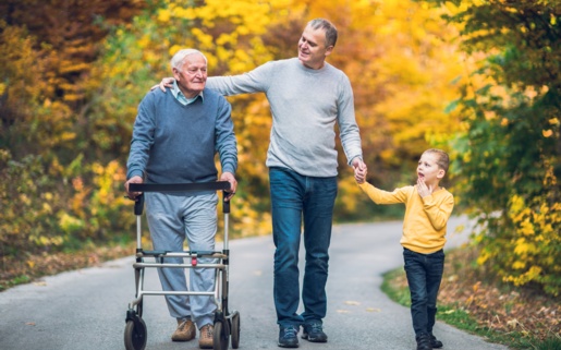 Picture of child, father and grandfather. Grandfather has a walking aid.