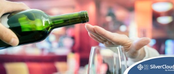 Image of hand over wine glass, while glass of wine being offered