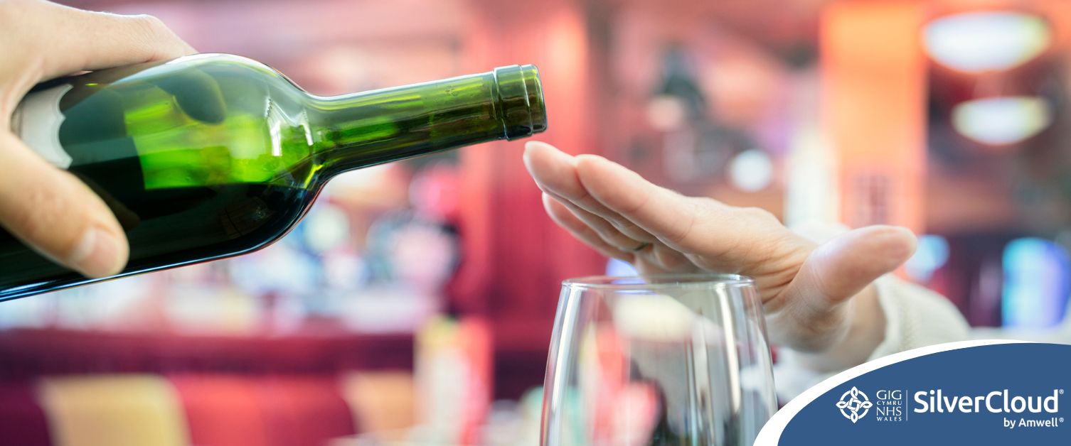 Image of hand over wine glass, while glass of wine being offered
