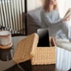 Woman sitting near window and reading book. Focus on box with smartphone. Digital detox and leisure concept