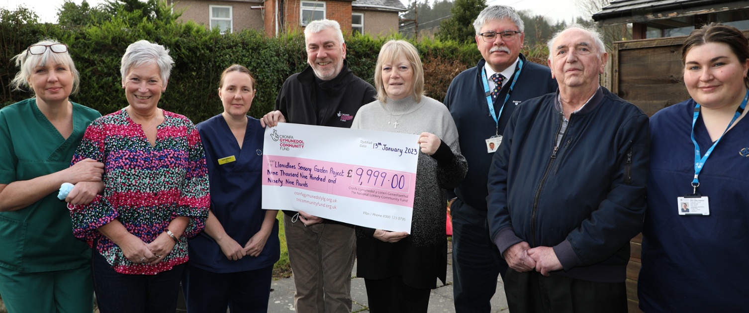 healthcare support workers along with members of partnerships holding cheque