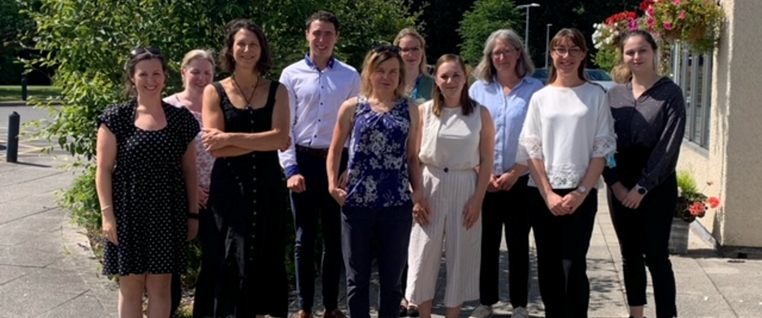 The Powys Teaching Health Board (PTHB) Dietetics Team members, stood outside beside a building for a group photo, with trees behind