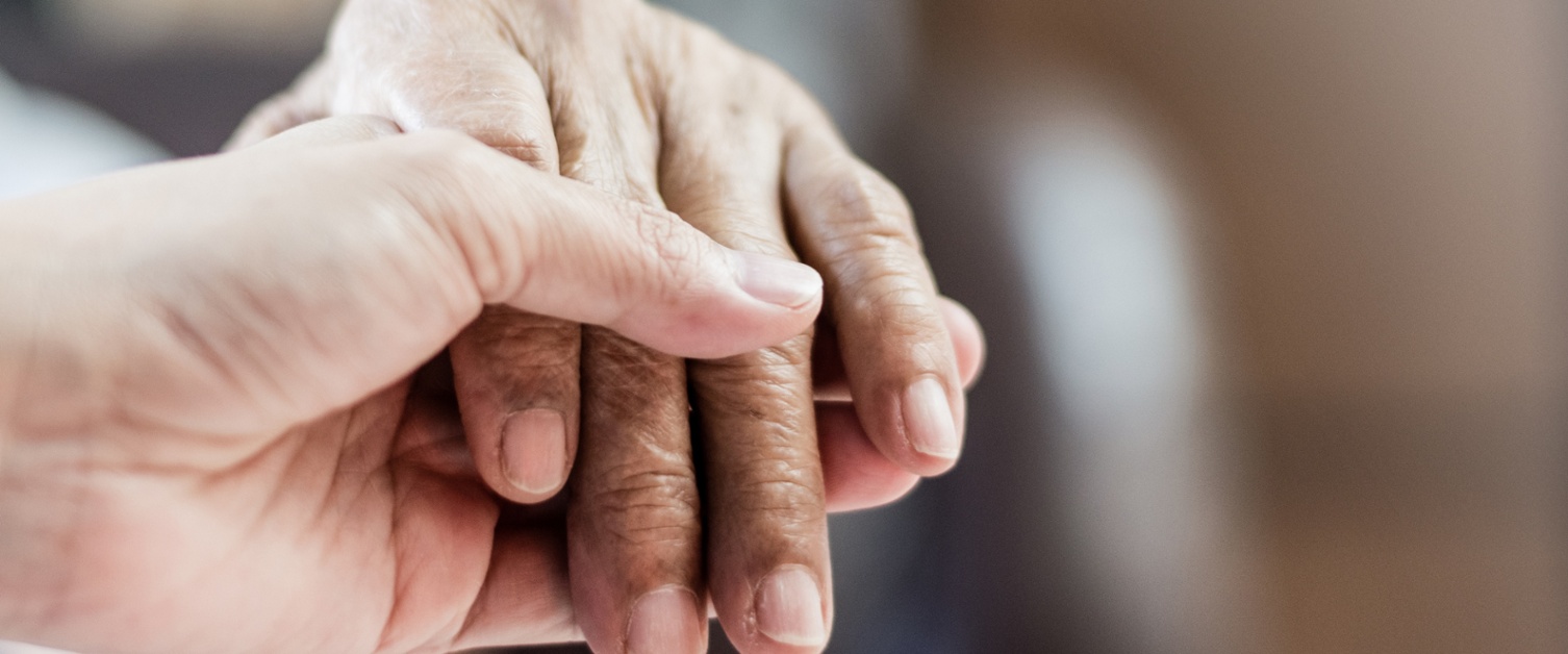 Close-up photo of two hands. The lower hand is an adult white person