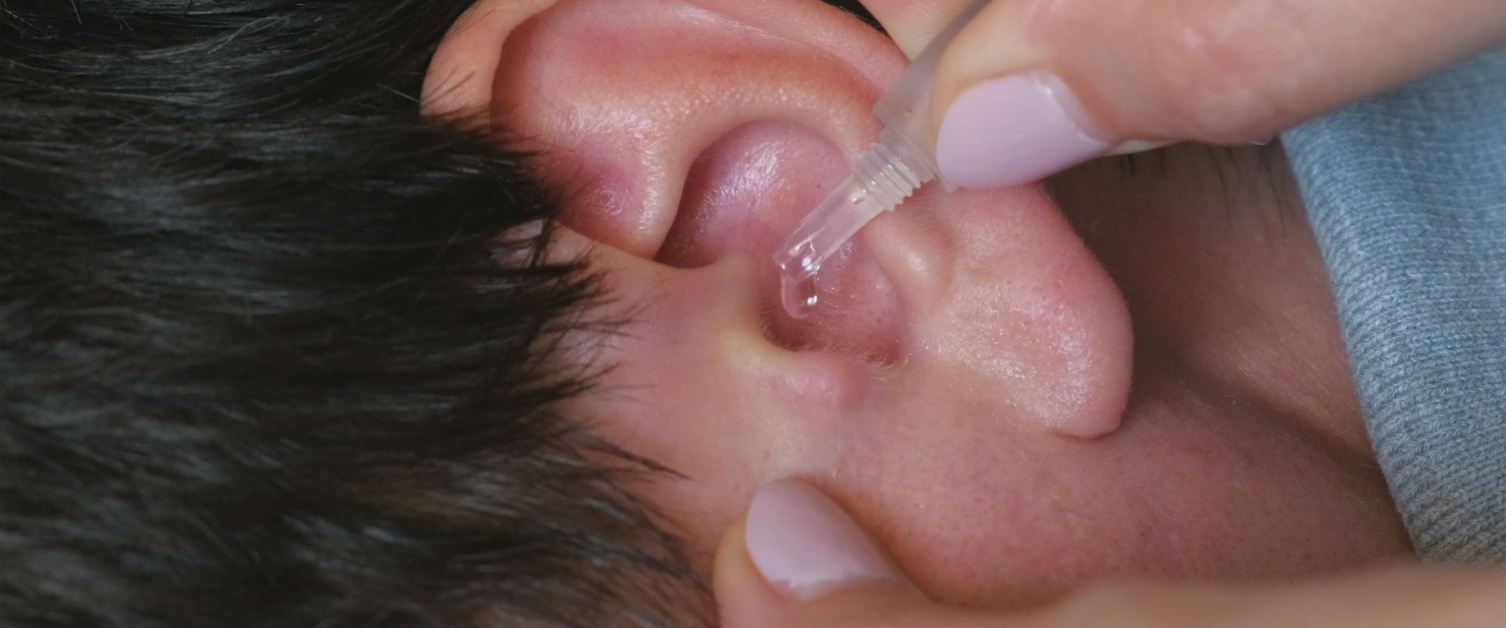 Female placing ear drops in child