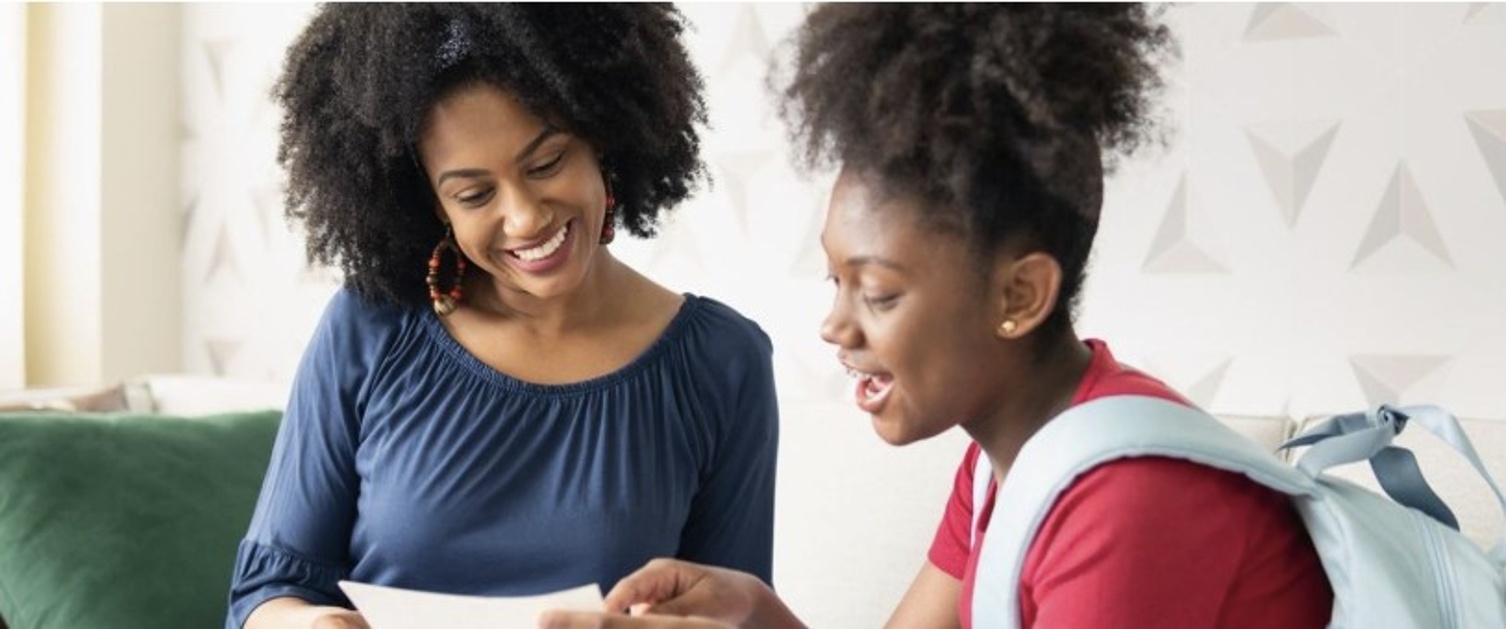 Image of Teenager showing exam results to parent in front room