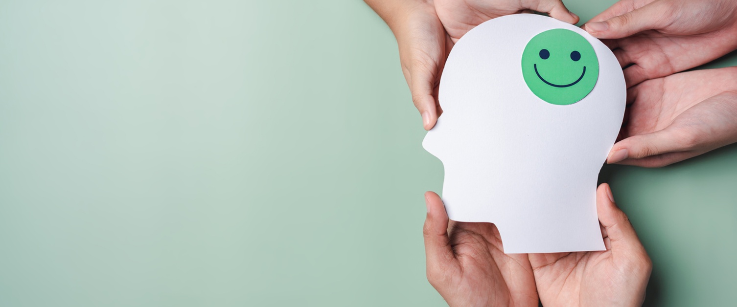 Image of hands holding smile face in brain paper cut, happy smiley emotion