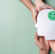 Image of hands holding smile face in brain paper cut, happy smiley emotion