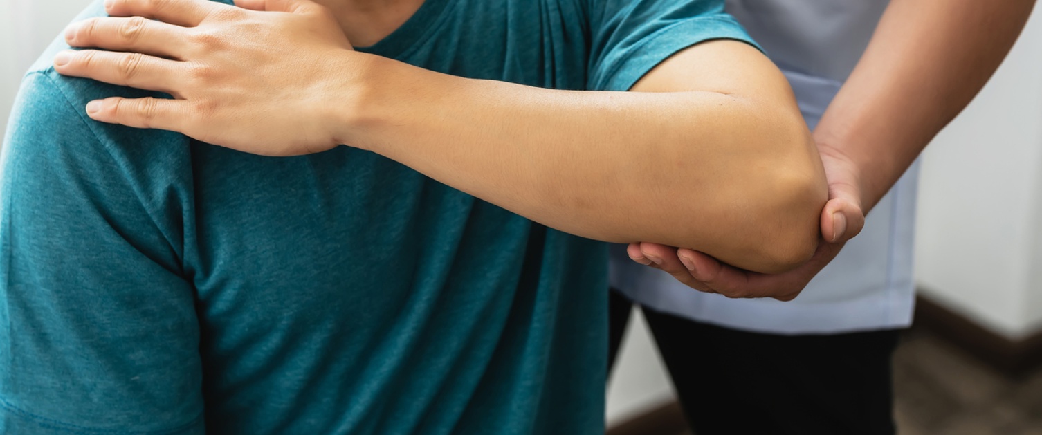 Close-up of a physiotherapist stretching to a man patient at the clinic.