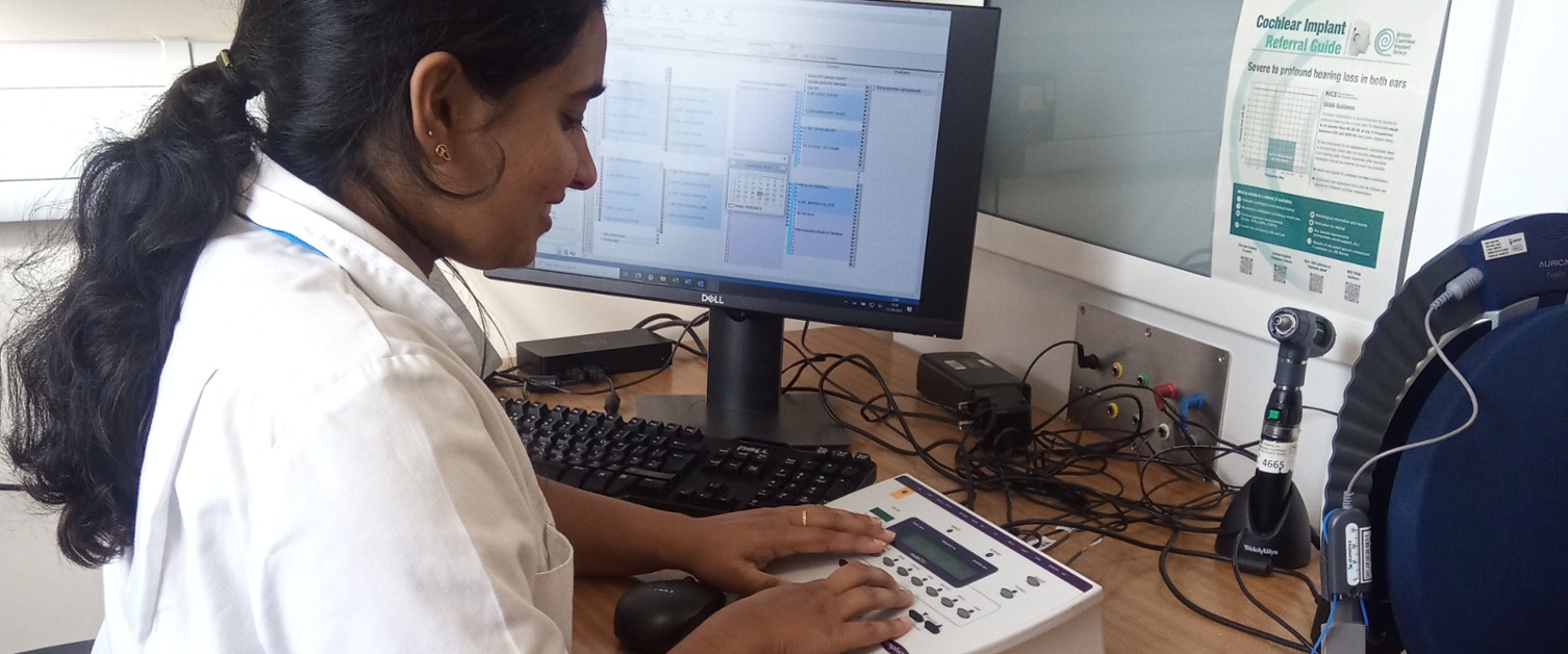Woman in Audiology team operating audiometer