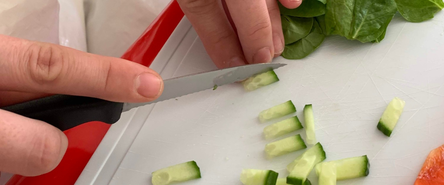 Person using knife to cut cucumbers in to small pieces