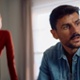 Image of looking away with worried expression on his face. Image of woman in background slightly blurred.