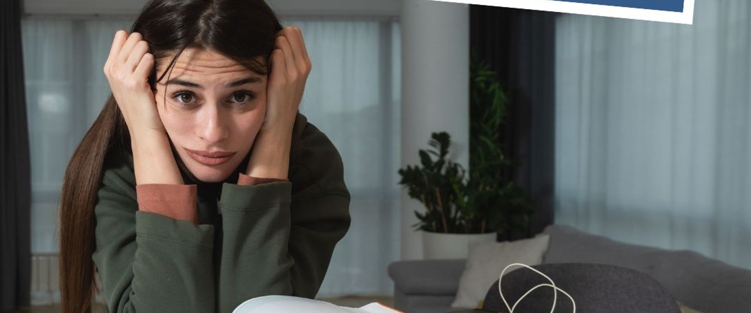 Text Reads: Worried about returning to Uni? Image of girl with hands on head and open book on table.