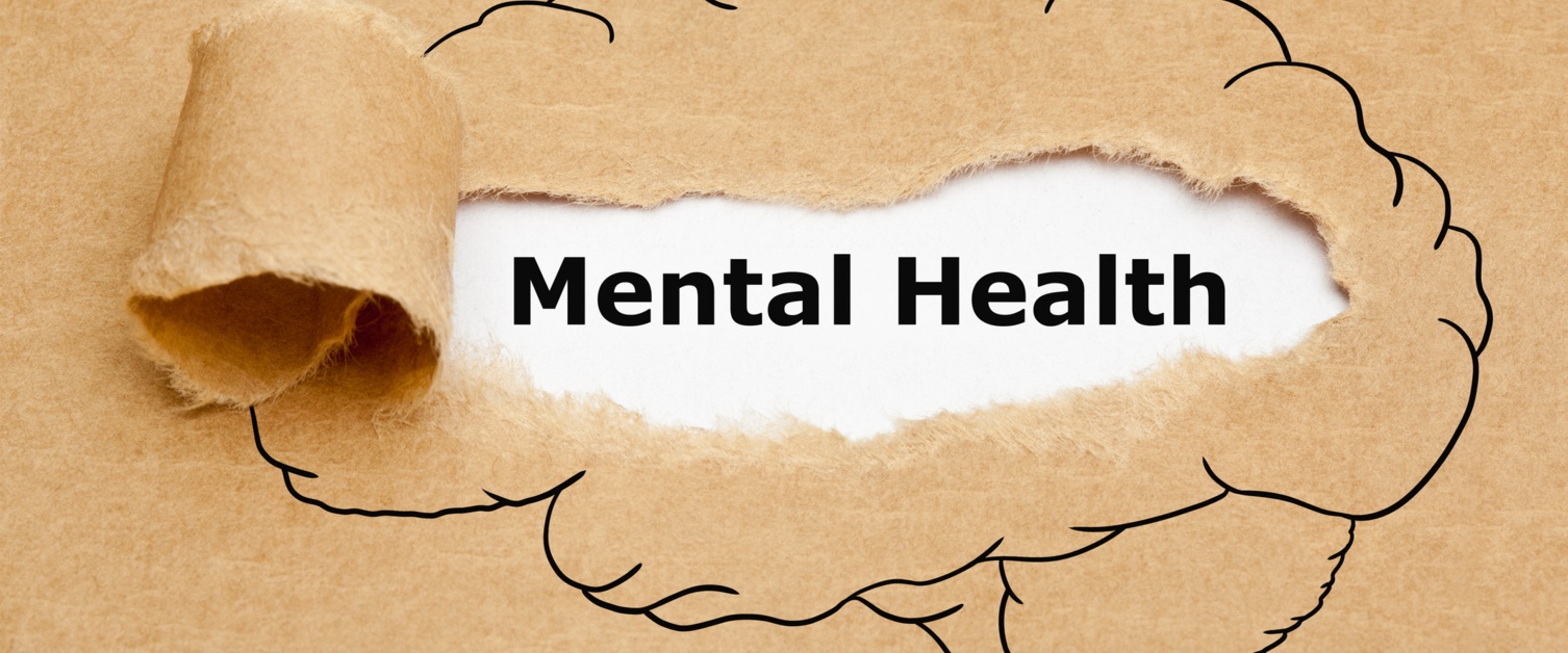 Text Mental Health appearing behind torn brown paper with drawn human brain on it.