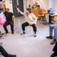 A room of patients sat in a chair circle, stretching their arms