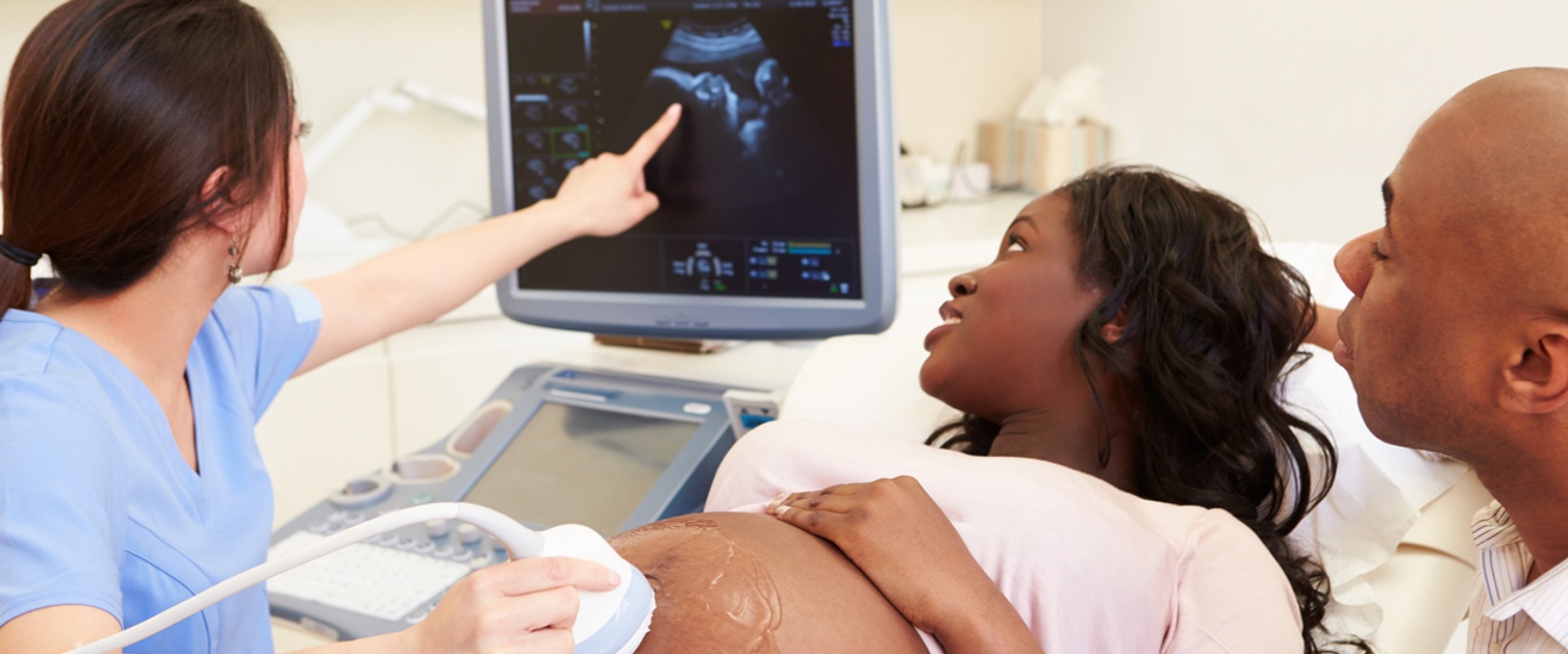 Pregnant woman and partner having ultrasound scan