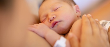 Close up of newborn in mothers arms