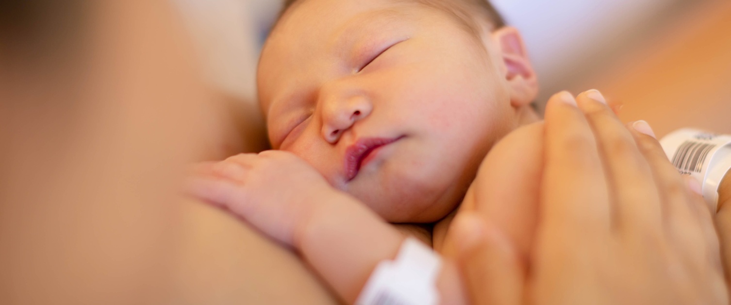 Close up of newborn in mothers arms