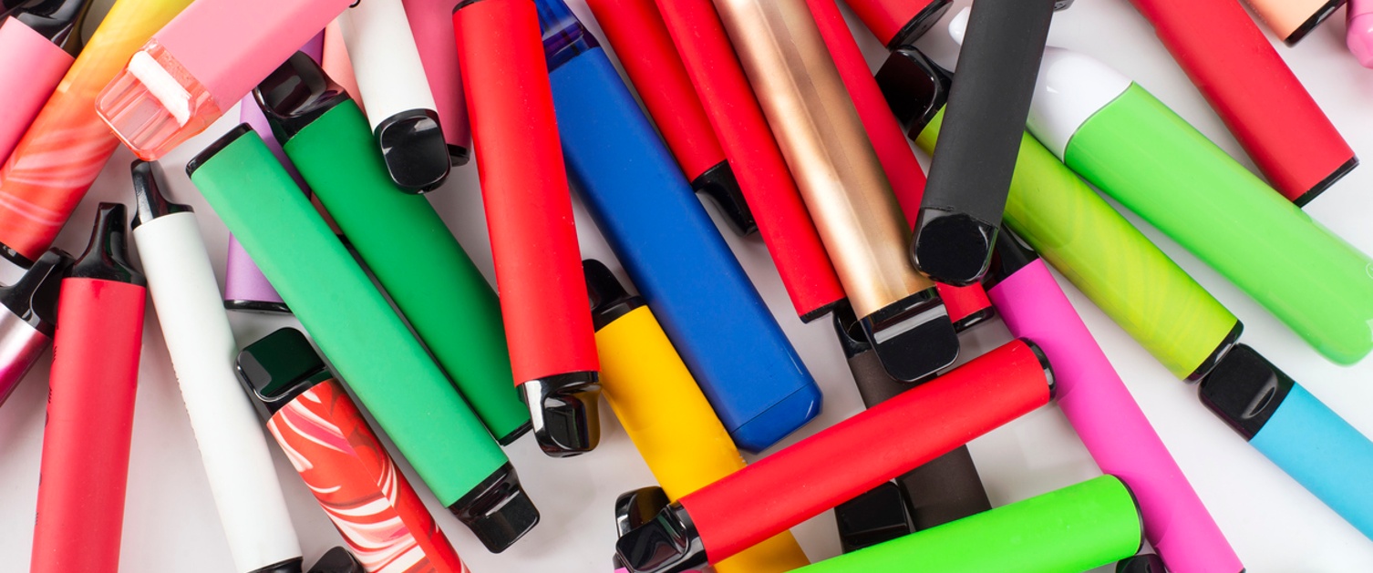 Set of colourful disposable electronic cigarettes of different shapes on a white background.