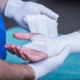 Close-up of male doctor bandaging a hand