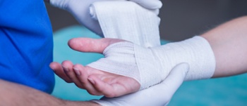 Close-up of male doctor bandaging a hand