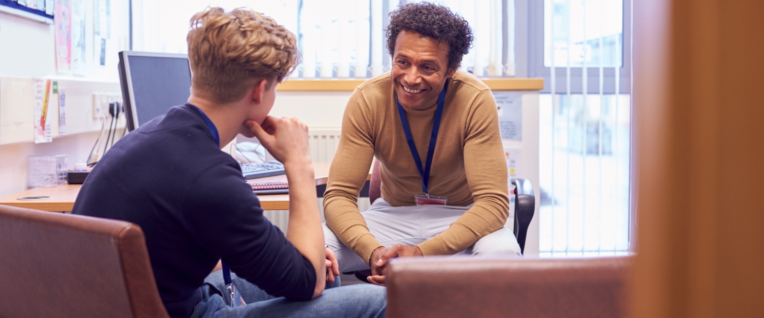 Young male talking to male member of staff