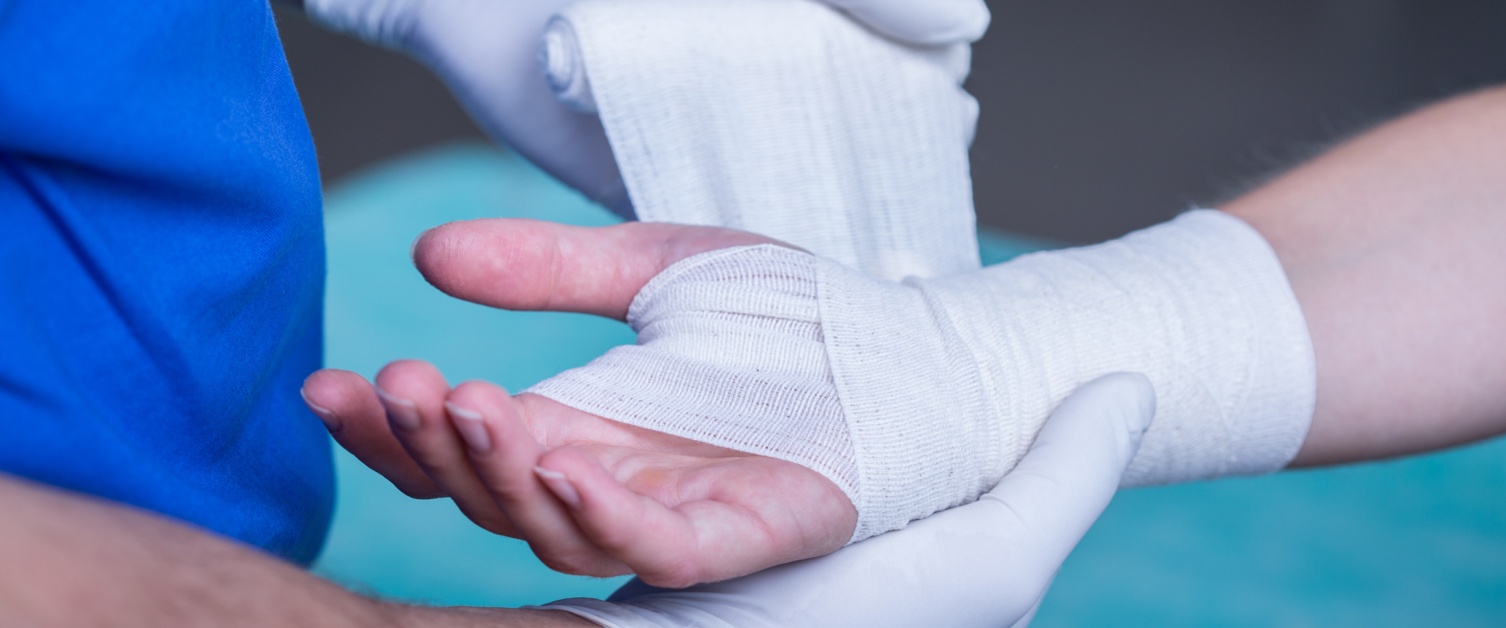 Close-up of male doctor bandaging a hand