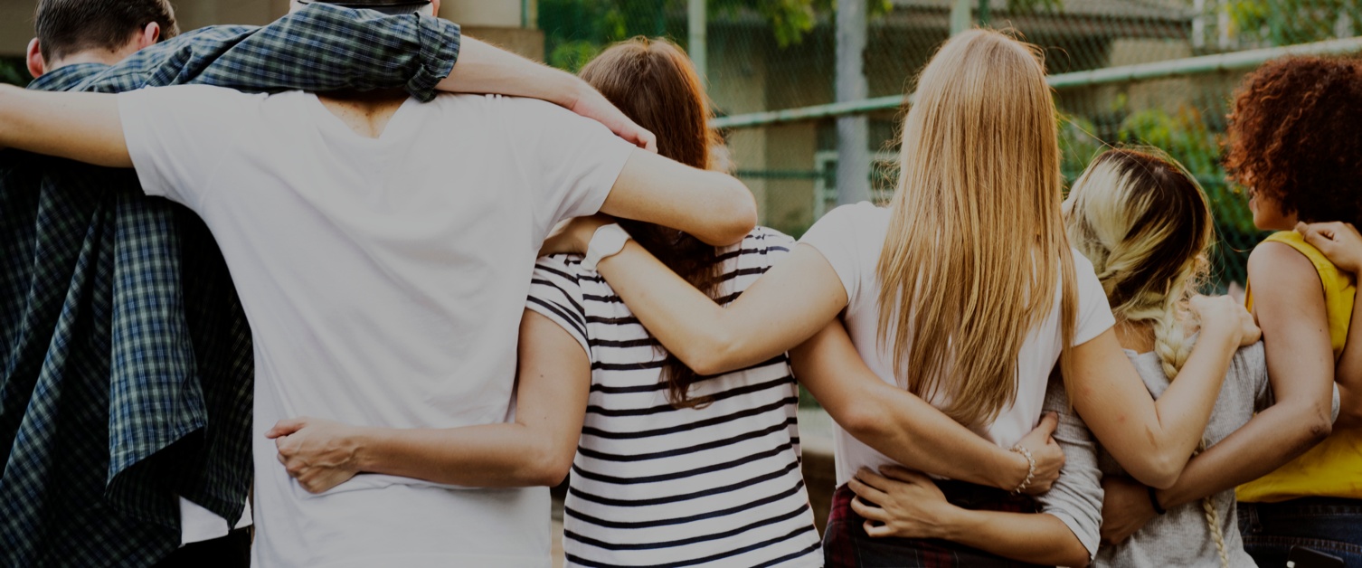 Smiling happy young adult friends arms around shoulder