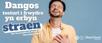 Darllen y testun: Dangoswch tosturi i frwydro yn erbyn straen mis ymwybyddiaeth straen 2025. Delwedd o ddyn yn edrych yn hapus.