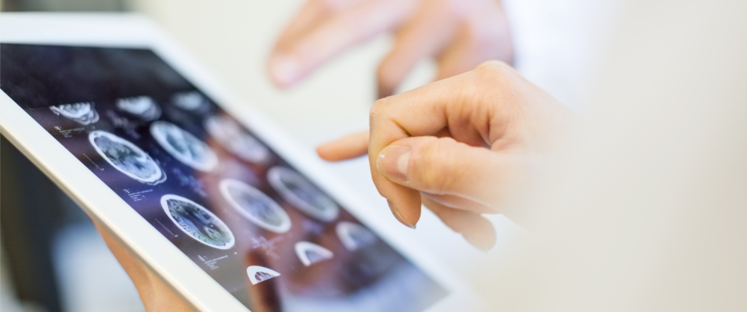 Medical team looking at MRI scan on tablet