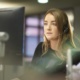 The image shows a member of staff wearing a headset working in an office responding to calls.