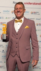 A man is holding an award.