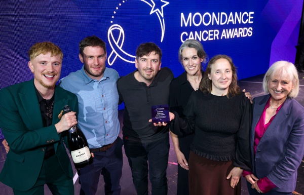 A group of people receive an award on stage.