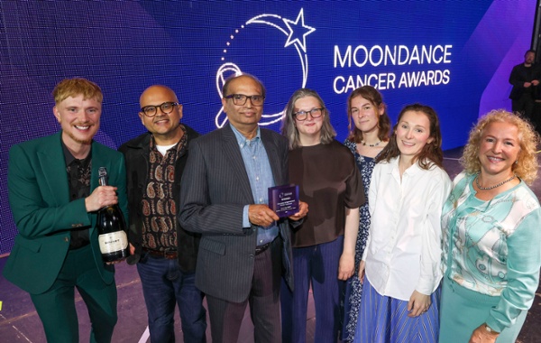 A group of people receive an award on stage.