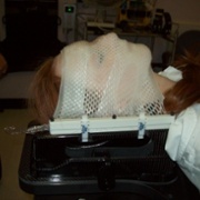 A person lying down with a meshed mask over their face.