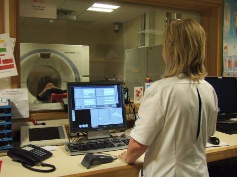 Radiographer watching patient on CT scanner