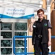 A person smiles and waves outside Velindre Cancer Centre.