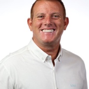 A man in a white shirt is smiling.