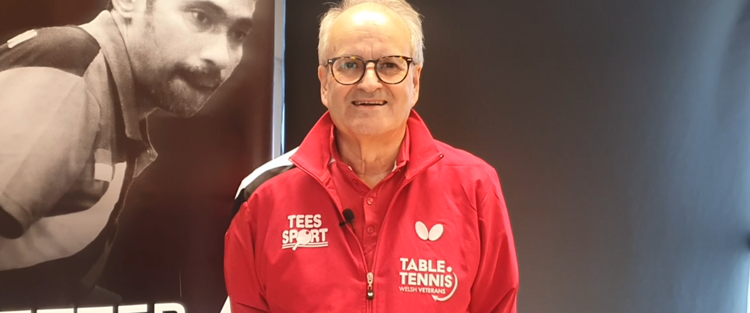 A table tennis player smiles to the camera.