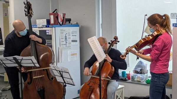 A group of people playing instruments in a clinical room.